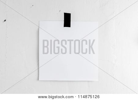 Blank White Poster Hanging On A Tape On The Wall. Template Backg