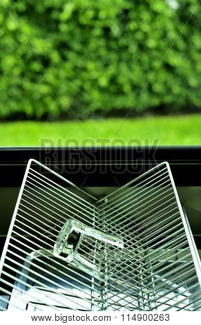 Outside the kitchen window, grille, glass upside down.