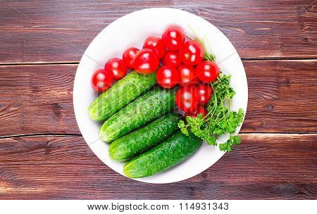 Cherry tomatoes, cucumbers and parsley in a plate, on an