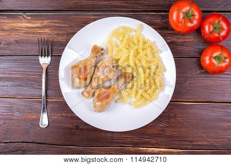 Vermicelli, chicken legs fried, and fresh tomatoes on an