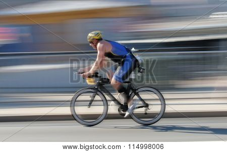 STOCKHOLM - AUG 23 2015: Rapid cycling man on a black advanced racing bike the speed makes it un-sharp at ITU World Triathlon event in Stockholm 2015