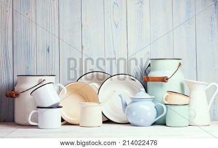 Enamelware on the kitchen table over blue wooden wall