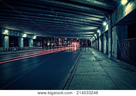Fire trucks, ambulance, police and traffic in a dark Chicago tunnel viaduct street at night. 