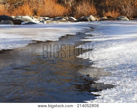 Thin ice on the river in late autumn. Walking through people is still dangerous cracks are formed.