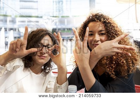 Couple Of Pretty Young Woman Showing Symbol Of Love