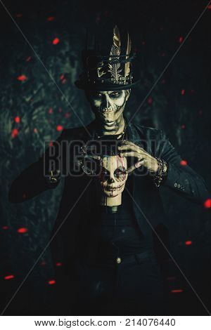 A man with a skull makeup dressed in a tail-coat and a top-hat. Baron Saturday. Baron Samedi. Dia de los muertos. Day of The Dead. Halloween.