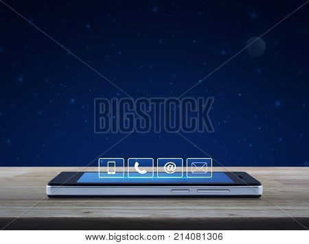 Telephone mobile phone at and email buttons on modern smart phone screen on wooden table over fantasy night sky and moon Customer support concept