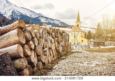 Church of Mary Visitation with cemetery and wooden beams in Zdiar village Belianske Tatry mountains Slovak republic. Travel destination. Yellow sun rays.