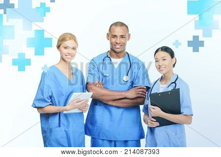 multiethnic surgeons with clipboard and digital tablet isolated on white