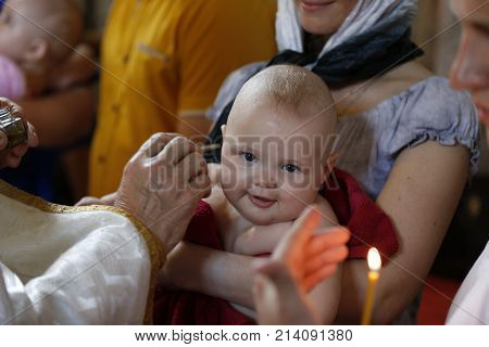 Belarus Gomel June 18 2016Holy Nicholas Monastery the Baptism of a Little Boy.Baptizing a child. Accepting faith. Joyful baby on baptism