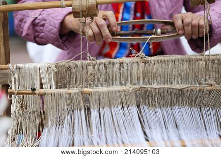 Belarus the city of Gomel June 3 2017. Independence Day in Belarus.Grandmother works behind an old spinning machine.Spice on an old spinning wheel. Ancient fabrication. Woman weaver