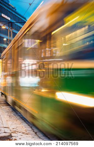 Abstract Photo With Tram Departs In Motion Blur From A Stop On Mannerheim Avenue In Helsinki. Night View Of Mannerheim Avenue In Kluuvi District In Evening Or Night Illumination.