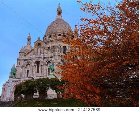 The basilica Sacre Coeur is a Roman catholic church located at the summet of the butte Montmartre , 