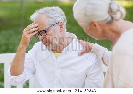 health, stress, old age and people concept - senior man suffering from headache outdoors