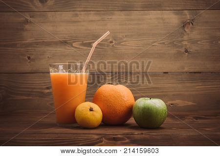Orange Juice In Glass And Fresh Fruits On Wooden Background