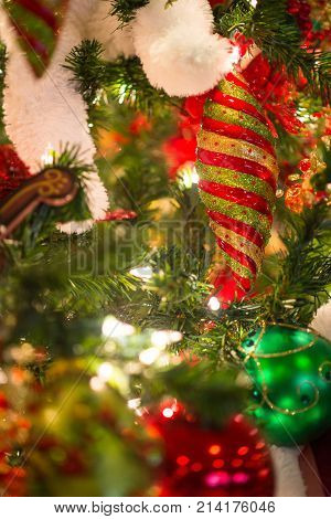 Multi-colored And Glitter Christmas Ornament Hang On Tree With Lights Sparkling Blurry In The Backgr