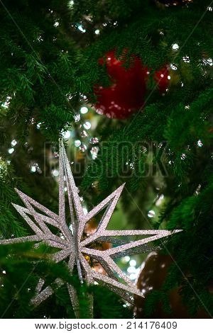 Big Silver Star Decorates Green Christmas Tree Covered With Blur Sparkle Lights