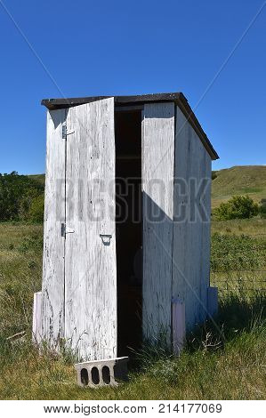 Old white house with an open door in the prairie hills