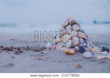 Sand castle on sandy beach with shells wall decorated added color filter