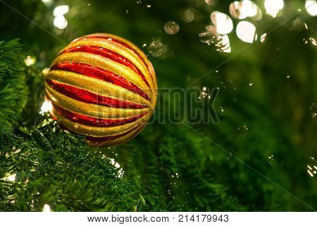 Christmas Background. With Sparking Lights And Green With The Multi-colored Ball In Focus On Side