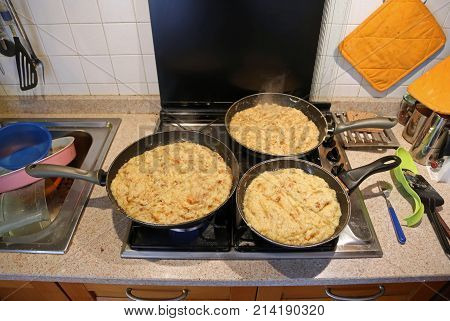 Three Big Pans With The Food Named Frico A Typical Italian Dish