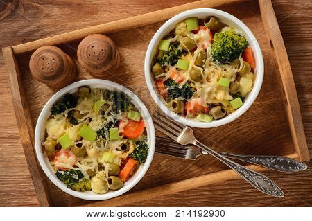 Casserole with vegetbales and cheese on wooden background..