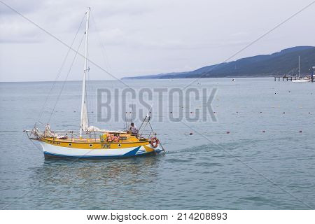 Lazarevskoe, Sochi, Krasnodar region, Russia - July 6, 2014: Sailing yacht departs from the beach in Lazarevsky