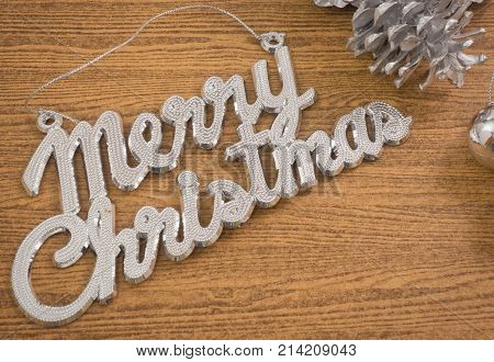 Xmas Ornaments Merry Christmas Text with Baubles and Pinecones on Wooden Table Sign for Christmas Celebration.