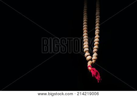 A Rosary With Beads On Wooden Textured Background.