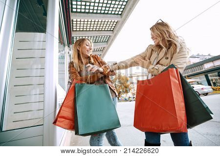 Black friday concept.Happy friends shopping. Two beautiful young women enjoying shopping in the city.