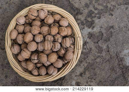 Basket with nuts on an old concrete background.