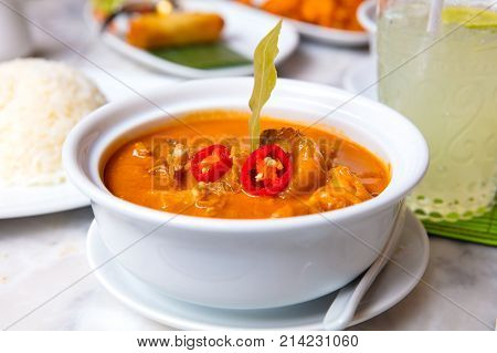 Massaman duck curry served in bowl on table at restaurant