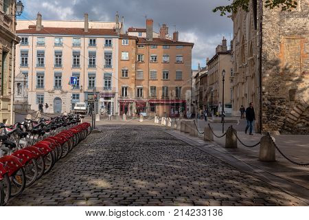Lyon France -- November 6 2017 -- A row of bicycles is parked by a cobblestone street leading to shops and restaurants in the old city section of Lyon. Editorial Use Only.