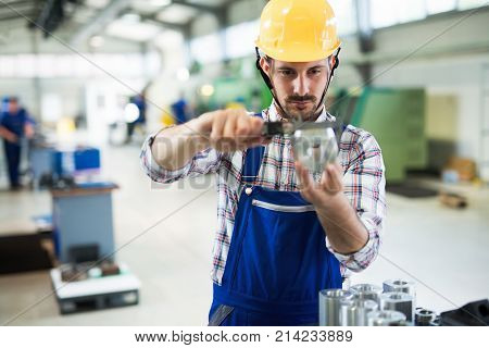 Supervisor doing quality control and pruduction check in metal factory