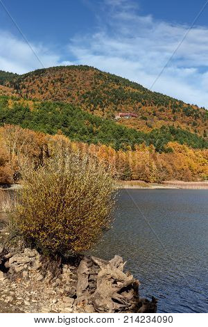 Mountain landscape. Scenic view of a mountain lake Feneos, mountains and autumn trees on a sunny day (mountain Corinthia, Greece)
