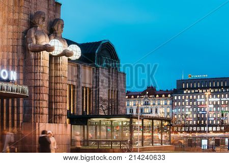 Helsinki, Finland - December 7, 2016: Night View Of Statues On Entrance To Helsinki Central Railway Station And Mikonkatu Street. Evening Or Night Illumination.