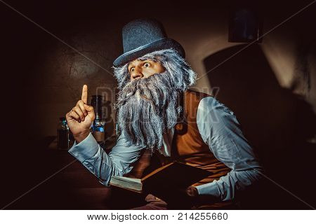 Bearded Man Wearing Black Hat And Vest With The Book.