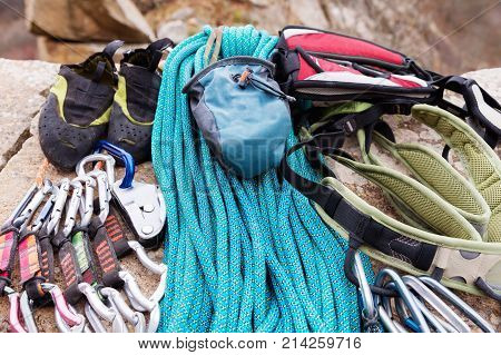Climbing equipment - bag for magnesia on the ground or carabines and rope on a background. Concept of outdoor sport