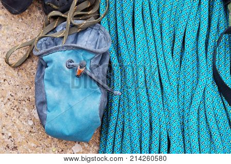 Climbing equipment - bag for magnesia on the ground or carabines and rope on a background. Concept of outdoor sport