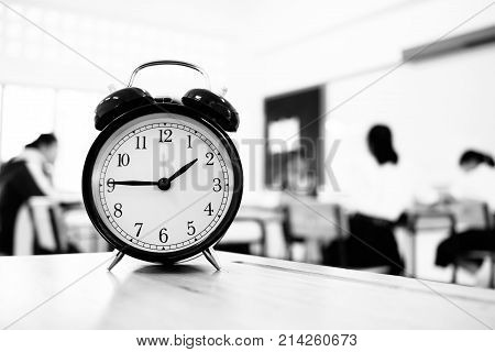 Alam clock located on wood teacher table in final exam room of secondary school college university classroom students in Asia Thailand. It show a timeout sign. in secondary school Education concept
