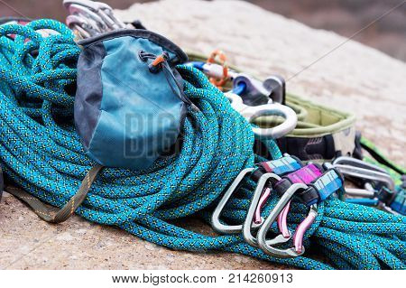 Climbing equipment - bag for magnesia on the ground or carabines and rope on a background. Concept of outdoor sport