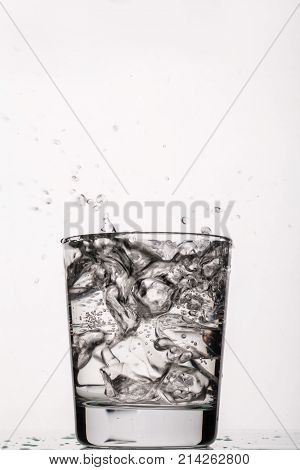 Crystals of ice falling into the glass of water