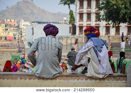 Indian men sitting and chatting on street in Pushkar India.