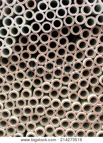 Plactic Plumbing connection fittings for plastic pipes. Orderly arranged in neat rows. Abstract industrial background.