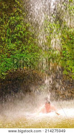 The tourist swimming at the waterfall at the Botanical Gardens in Saint Lucia at island at Caribbean sea