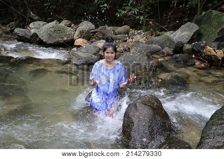 Women are splashing water of the falls.