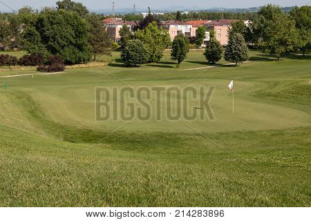 White Flagstick in Green Golf Course in Sunny Day.