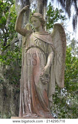 THUNDERBOLT, GA - October 8, 2017 A monument of an angel holding a wreath and adorned with a star in her hair watches over the departed at Bonaventure Cemetery.