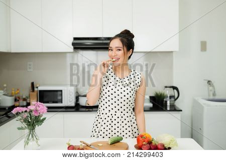 Asian Wman Preparing Healthy Meal In Her Rustic Eco Kitchen