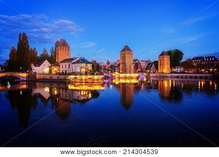 medieval bridge Ponts Couverts of Strasbourg illuminated at night, France, toned